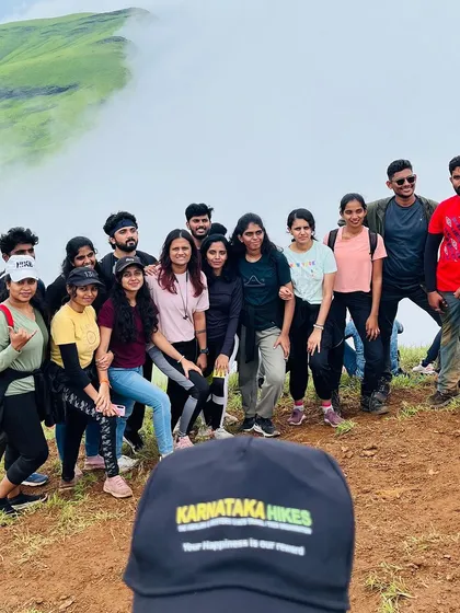 A happy group photo on the Netravathi trail, with our trek lead's cap in the foreground.