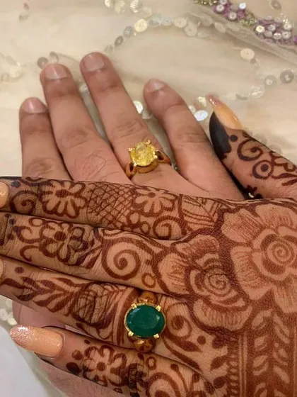 A close-up of a beautiful floral mehendi design for an engagement. The intricate patterns on the hands and fingers are designed to complement the couple's engagement rings perfectly.