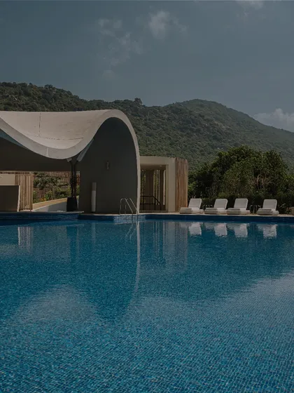 The poolside lounge chairs at the Aqua spa offer a place for relaxation with a direct view of the hills, under the partial cover of the building's unique roofline.