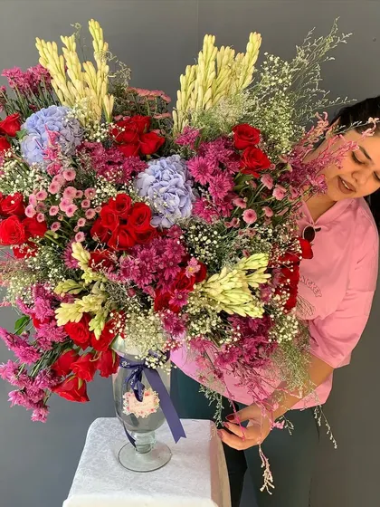 Here I am putting the finishing touches on a massive, colorful bouquet. Every arrangement gets my personal attention to ensure it's absolutely perfect before it goes out.