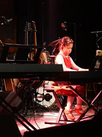 One of our youngest pianists performing her piece on the keyboard. We ensure even our beginner students feel like stars on the big stage.