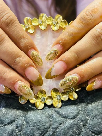 An intricate design with a gold glitter outline creating a "geode" or "cutout" effect on the nail.