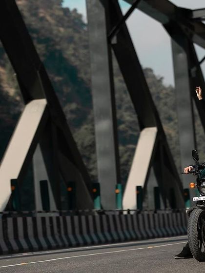 A dynamic action shot of the couple riding a motorcycle across a bridge. This captures a sense of freedom and adventure, making for an exciting pre-wedding photo.