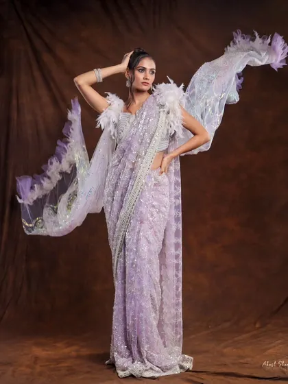 A powerful pose in a lavender sequined saree. The model's stance and the flowing, feathered pallu create a look of an ethereal angel or warrior.