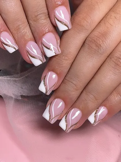 A classic square-tipped French manicure with a twist. This design features an elegant gold glitter swirl separating the pink base from the white tip.