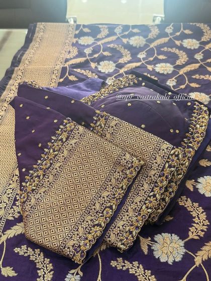 A purple blouse with a geometric and floral embroidered sleeve design.