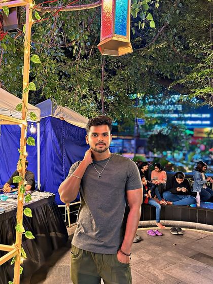 At a night market or festival in Bengaluru, surrounded by lights and crowds.