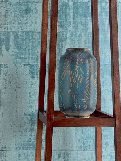 This design from the Atelier d’Artiste collection infuses a space with a harmonious blend of vibrant energy and calming serenity. The coated raffia texture in blue adds both color and a tactile quality.