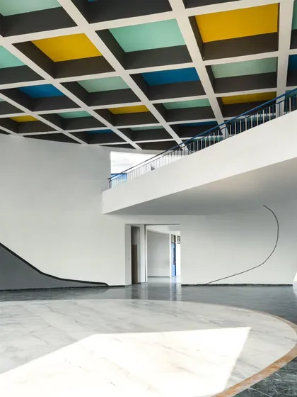 The interior of the school features clean lines, curved walls, and a beautiful interplay of light and shadow, creating a sophisticated yet child-friendly space.