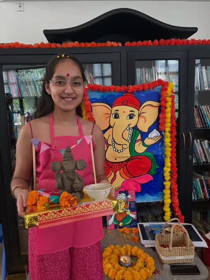 Another happy artist with her complete Ganesha setup, including a hand-sculpted idol and a decorated platform.