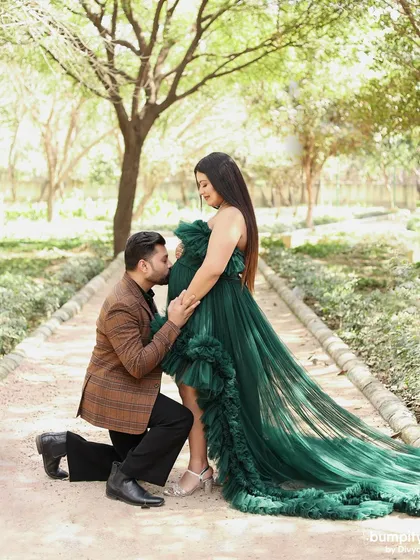 A tender and classic maternity pose, with the dad-to-be kneeling to kiss the baby bump. A truly heartwarming moment captured forever.