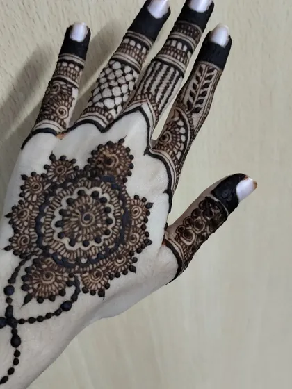 A beautiful mandala design on the back of the hand, connected to the fingers with a delicate chain. This is a great choice for a simple yet stunning look.