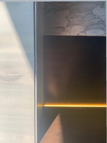 A glowing line of light is integrated into the base of a wall, creating a subtle and beautiful effect. This detail highlights the intersection of different materials and adds a warm, linear accent.