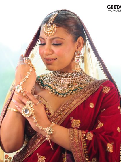 Student Work: A final bridal look featuring a beautiful velvet lehenga and intricate jewelry. The student has created a soft, glowing makeup look that enhances the bride's natural beauty.