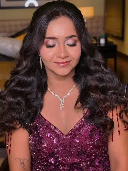 Eyes closed to show the delicate blend of glittery eyeshadow for this soft glam reception look.