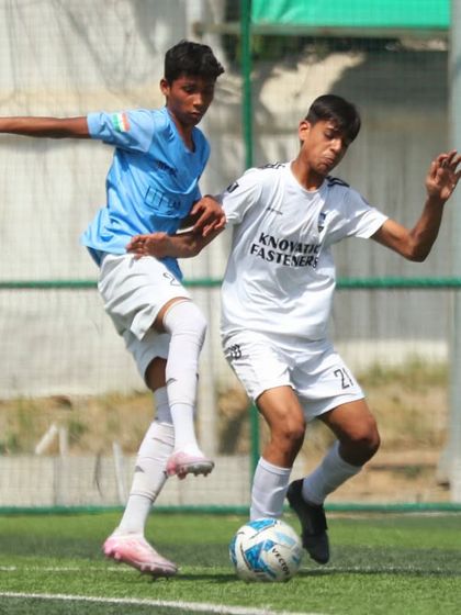 A mid-air challenge for the ball. Our players are trained to be aggressive and fearless when contesting for possession.