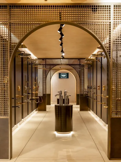 Arched entryways and metal gridwork create a sense of passage and discovery within the Grohe showroom. This architectural element separates product zones while maintaining an open, cohesive feel.