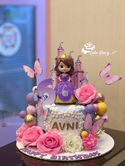 A royal celebration for Avni's 5th birthday with this Princess Sofia cake. The design includes a beautiful Sofia figurine, a castle backdrop, fresh pink roses, and delicate butterflies.