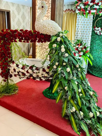 Welcoming a new life is a precious occasion. For this naming ceremony, I sculpted an elegant peacock from fresh flowers and foliage, with its cascading tail gracefully draping over the baby's cradle. It’s a bespoke piece that adds a touch of artistry to the celebration.