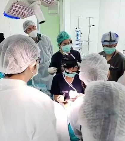 The operating room during a live surgical workshop, with multiple trainees observing and participating. This immersive approach is the fastest way to build surgical competence.