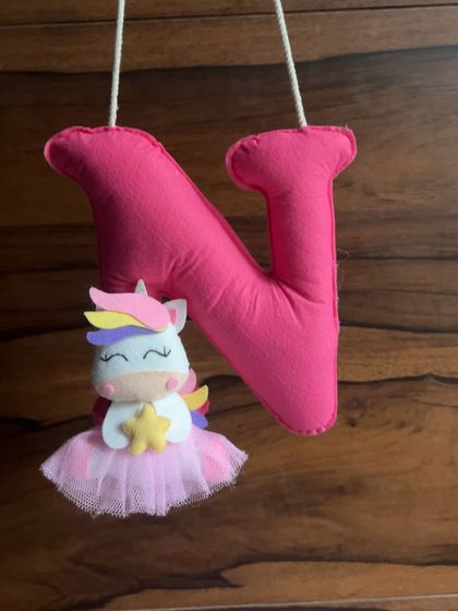 A custom-made felt initial "N" with a unicorn, a sweet decorative piece from Nidhi's first Rakhi hamper.