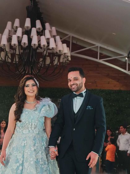 The couple makes their entrance under a shower of sparks. The bride's makeup is flawless and radiant, ready for the party.