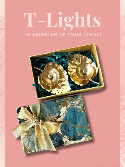 A set of two golden leaf-shaped T-light holders in a gift box. The delicate design is perfect for adding a touch of nature-inspired elegance to your decor.