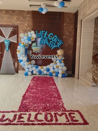 A grand 'Welcome Baby' entrance decoration. I used a blue and white balloon ring and a rose petal carpet to create a special welcome for the new baby and mother.