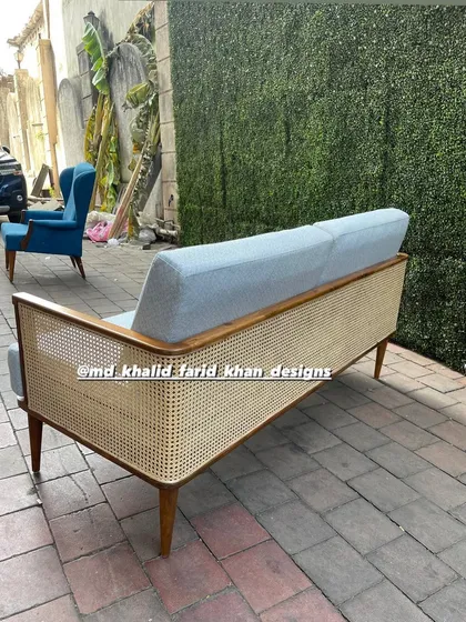 Back view of the caned sofa, showing the full-length cane panel.