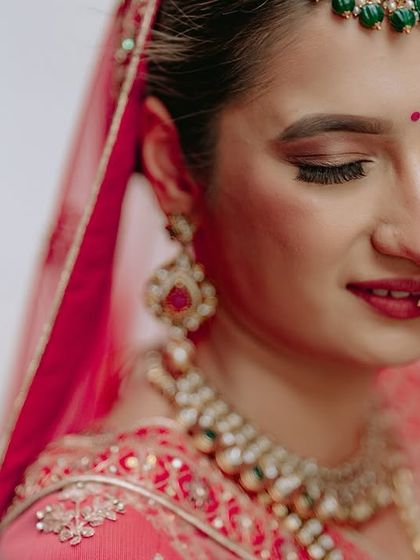 A delicate close-up of the bride's face, capturing her flawless makeup and the intricate details of her nath (nose ring).