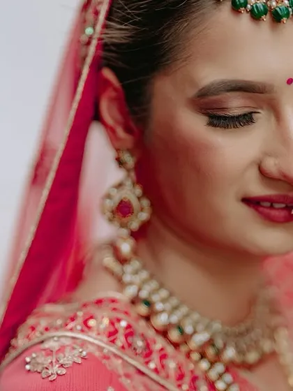 A delicate close-up of the bride's face, capturing her flawless makeup and the intricate details of her nath (nose ring).