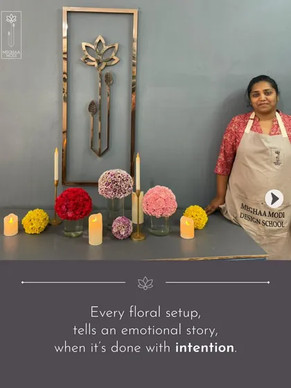 Every floral setup tells an emotional story when it's done with intention. This student stands by her work, a carefully composed scene using candles and monochromatic floral spheres to create a serene mood.