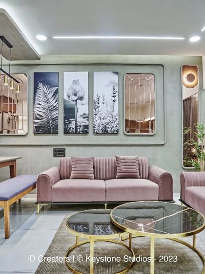 The full living room setup, showing the balance of soft colors, metallic accents, and modern art in a compact apartment space.