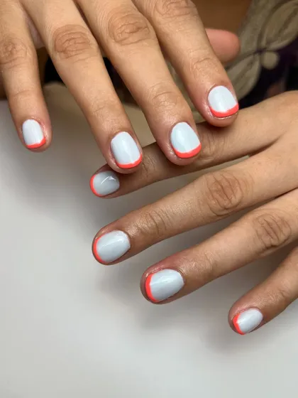 Sometimes simple is best. This clean look features a milky white base with a fine, bright orange micro-French tip for a subtle pop of color.