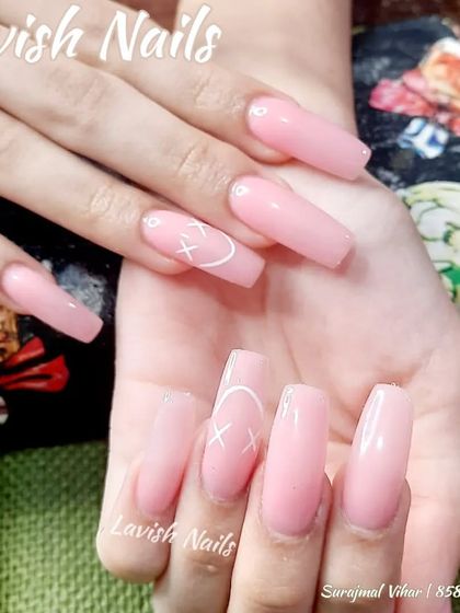 Long, glossy pink coffin nails with a simple, edgy heart and 'x' design on the accent nail.