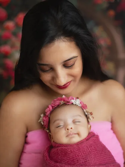A mother's love captured in a quiet, tender moment with her newborn daughter. The floral background adds a soft, feminine touch.