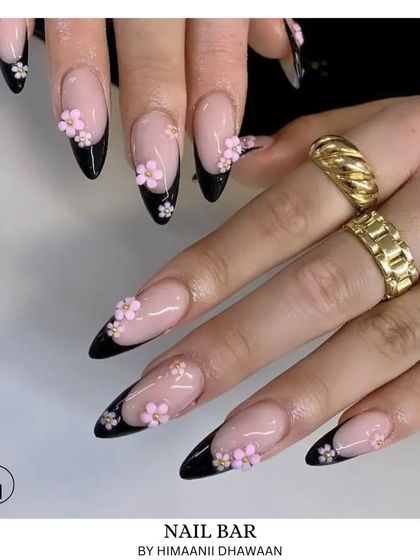 Elegant black French tips are elevated with delicate 3D pink flowers. This design perfectly balances classic style with a modern, artistic touch.