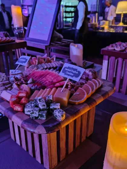 Another angle of the cheese board, highlighting the vibrant colors of sliced watermelon and fresh strawberries alongside different types of cheese. We focus on using fresh, high-quality produce to make our grazing tables stand out.