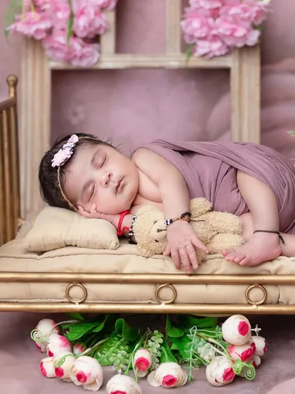 A beautiful side-sleeper pose on a miniature golden bed, surrounded by flowers.