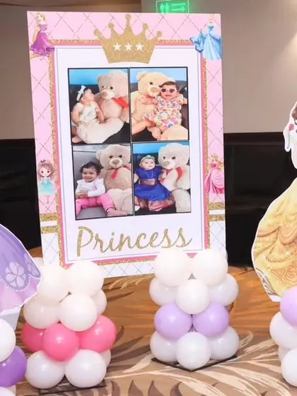 Custom decor elements for a princess party, including character pillars and a personalized photo frame stand.