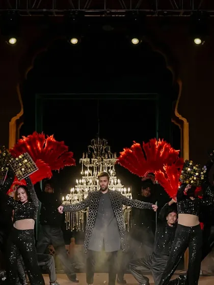 A groom's performance with a unique, artistic flair. We used large, colorful fan props and dramatic smoke to create a visually stunning act against the backdrop of grand chandeliers.