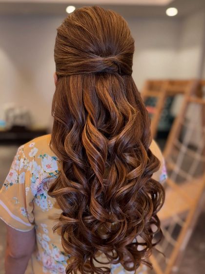 Half-tied up in love. This simple yet elegant half-up style features a neat twist and beautiful curls, perfect for any wedding event.