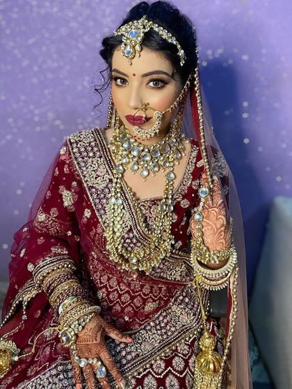A regal portrait of my bride in a deep maroon lehenga. The makeup features a strong contour and bold eyes, designed to stand out and create a powerful, queenly presence.