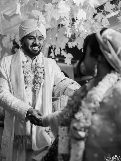 A classic black and white shot of the groom's joyful reaction upon seeing his bride. This timeless style emphasizes the raw emotion and makes the moment feel even more significant.