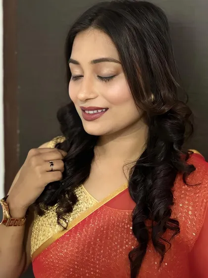 The perfect combination of a simple red saree and elegant makeup. The soft curls and defined eyes create a look that is both timeless and beautiful.