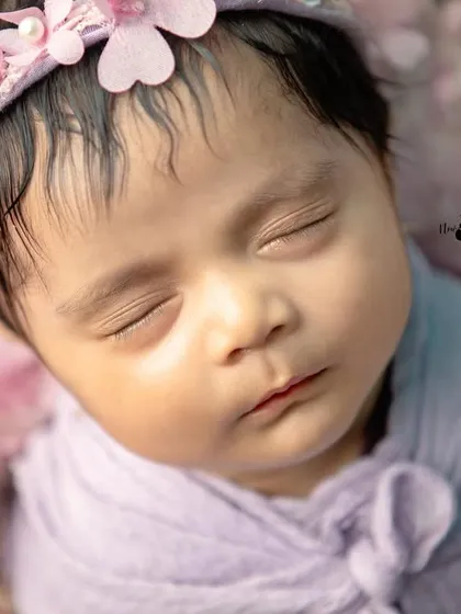 An intimate macro shot of a newborn's face, highlighting the soft skin and tiny features that change so quickly. These are the details you'll want to cherish.