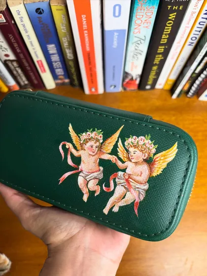 I've been fascinated by Renaissance art lately. Here, I painted two cherubs on a dark green jewelry box, bringing a classic art style to a modern accessory.