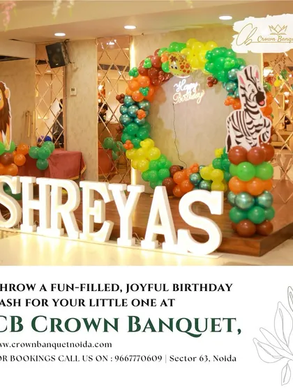 A fun-filled jungle-themed birthday bash. The large light-up name is surrounded by a green and orange balloon arch with animal cutouts, perfect for a little explorer's party.