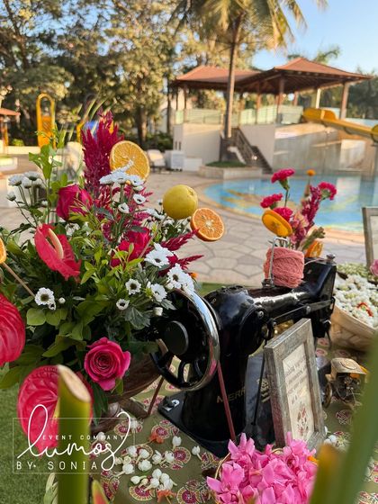 A close-up of the floral arrangement on the antique sewing machine, with a pool in the background.