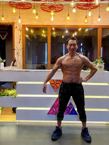 Posing to show off his well-defined physique. We believe in celebrating the hard work and results of our members, who prove that a strong body is achievable at any age.